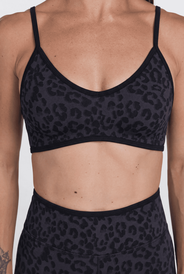 Black leopard print sports bra and leggings on a plain background