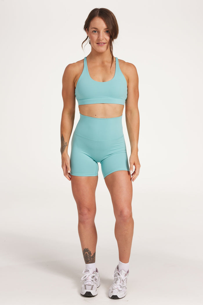 high waisted gym shorts, in buttery soft, supportive fabric with 6 inch inseam and no front rise seam, in lagoon green with women's moderate support activewear bra in buttery soft fabric with stunning triangle open back detail and scoop neckline