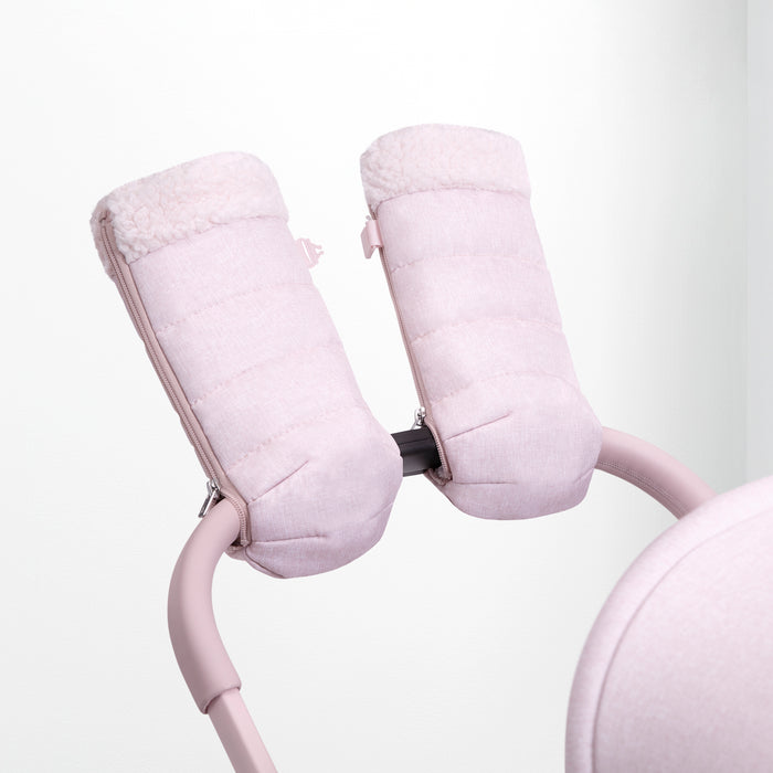 A pair of pink babyGap Stroller Handmuffs attached to a stroller, with thick sherpa lining visible.