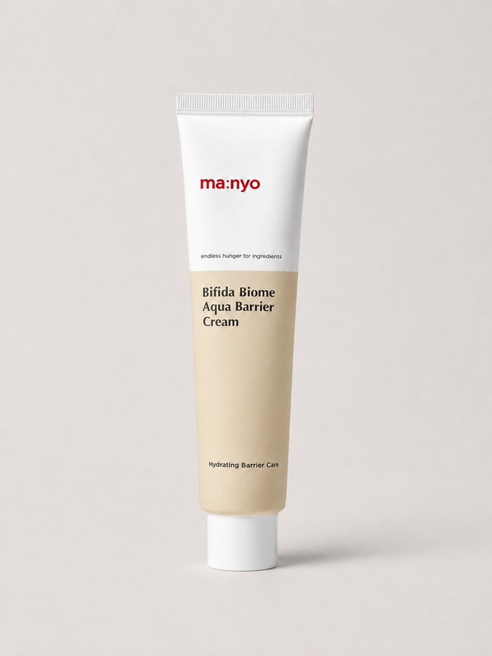 A korean skincare tube of ma:nyo Bifida Biome Aqua Barrier Cream, featuring a white upper section with red brand text and a beige lower section, set against a solid light gray background. 80 ml.