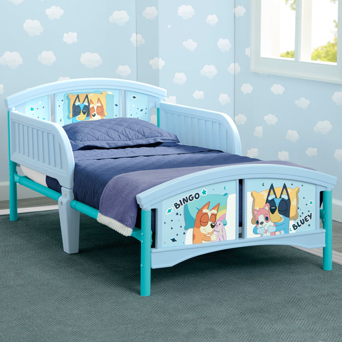 Children's bed with cartoon character panels in a room with polka dot wallpaper.