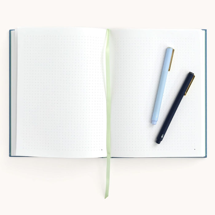 Open notebook with two pens on a white background