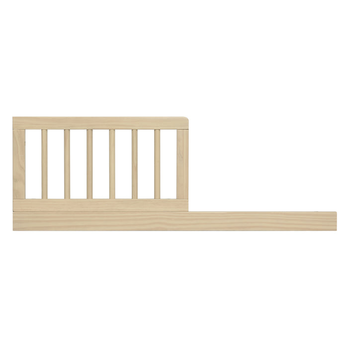 A beige wooden toddler guardrail designed to convert a crib into a toddler bed or daybed.