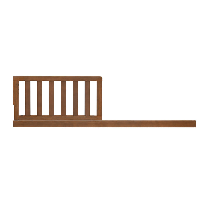 A brown wooden toddler guardrail kit designed to extend the life of a crib by transforming it into a secure toddler bed or daybed.