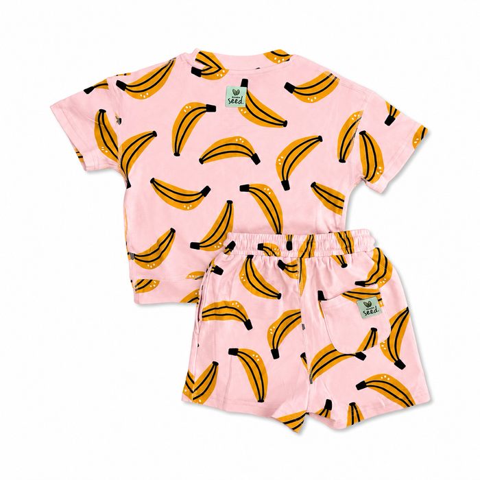Children's pajama set with banana pattern on a pink background