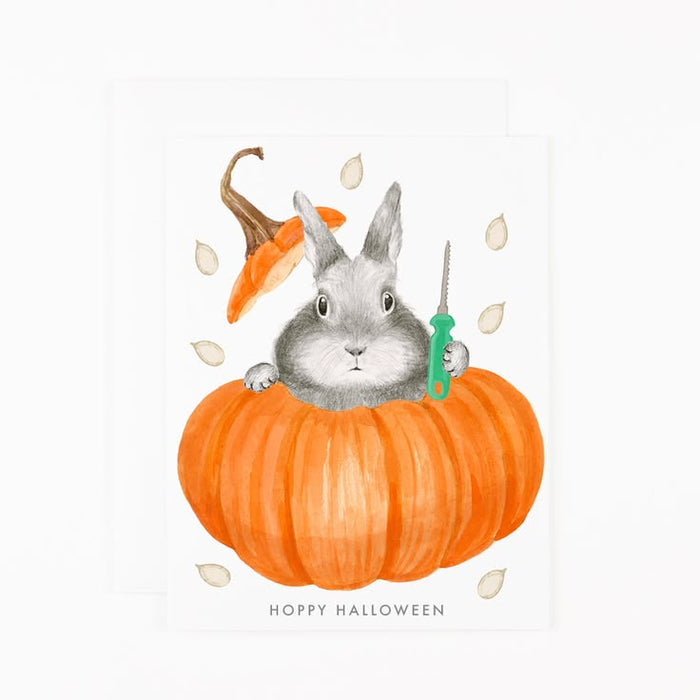 Illustration of a rabbit in a pumpkin with a carrot, leaf, and syringe on a white background.