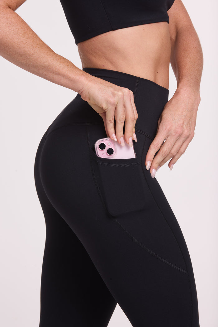 Buttery soft high waisted women's gym tights with practical pockets, sweetheart back seams for an upper glute shaping effect, and no front rise seam, paired with an V neck women's crop t-shirt with a supportive elasticated hem and triple layered fabric with removable pads for extra support in black