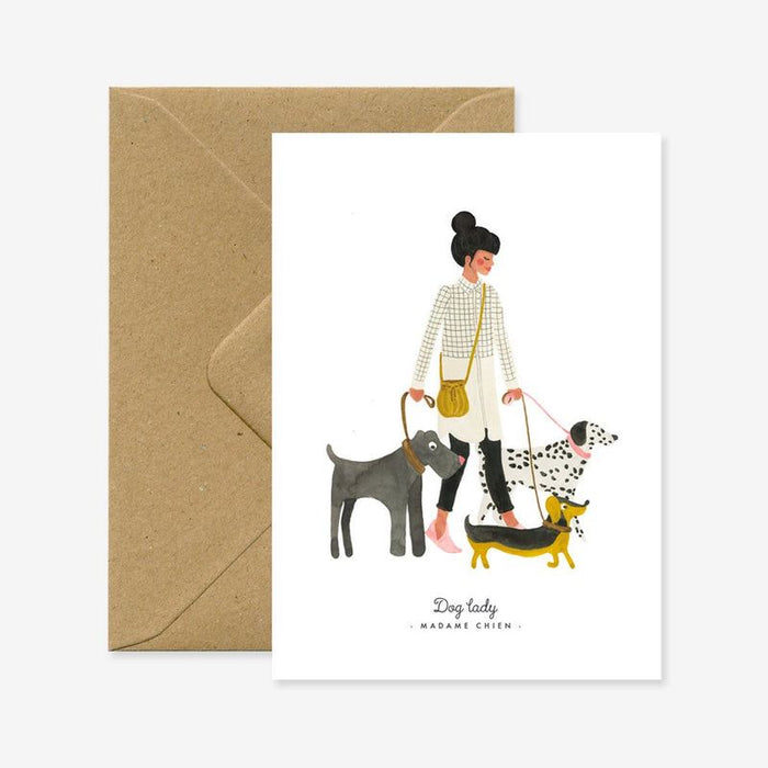 Greeting card with illustration of a woman walking three dogs, accompanied by a brown envelope.