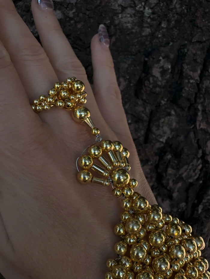 beaded detail of modular hand jewelry and ring in gold by object and dawn close up