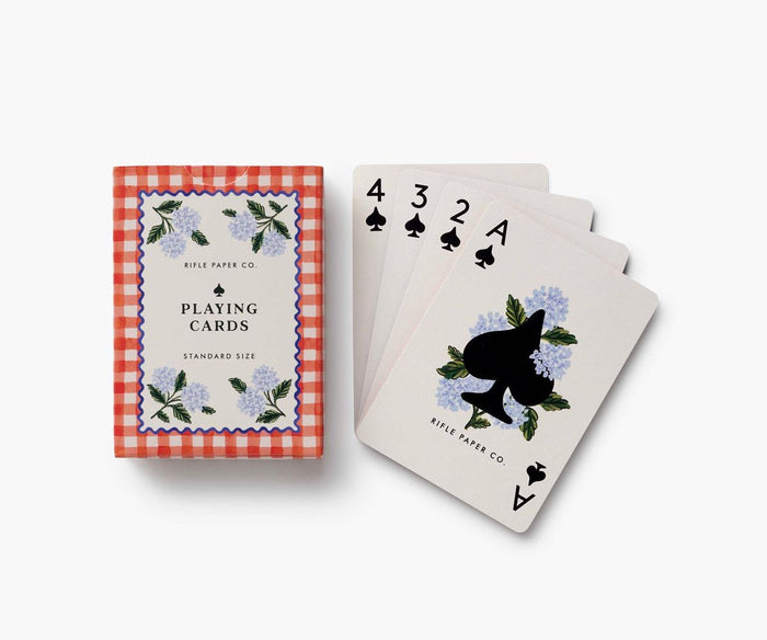 Playing cards with floral and black cat design on a white background