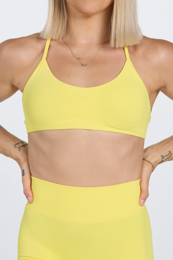 Seamless women’s gym bra with an ultra thin racerback strap design, with white PEPPAMINT branding on the back strap in buttercup yellow
