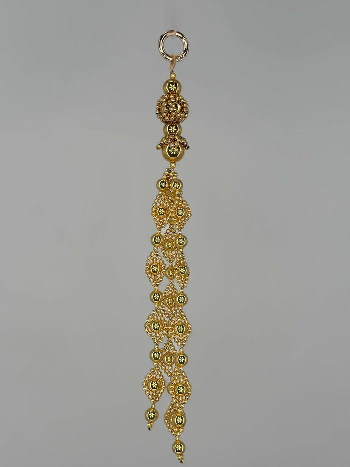 Beaded trinity medallions from polymer metal beads with 22k gold washed by object and dawn on neutral background