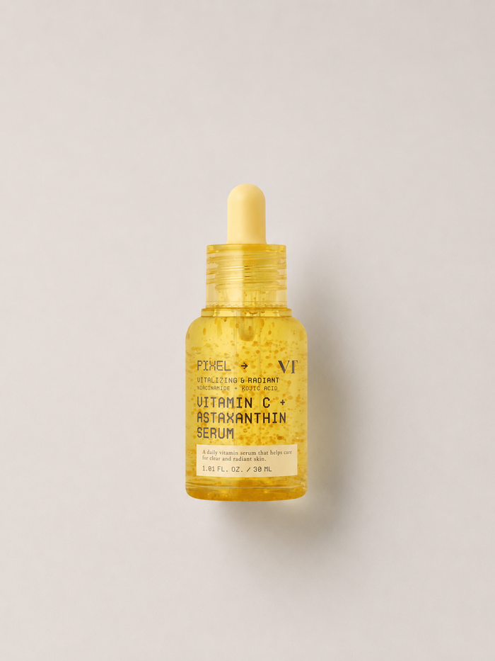 A korean skincare serum - small glass dropper bottle of VT cosmetics Vitamin C & Astaxanthin Serum filled with golden-yellow liquid, centered on a light gray background. 30 ml.