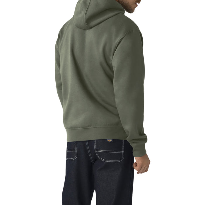 Man wearing sage green hoodie with hood and drawstrings, paired with dark denim jeans, shown from back angle.