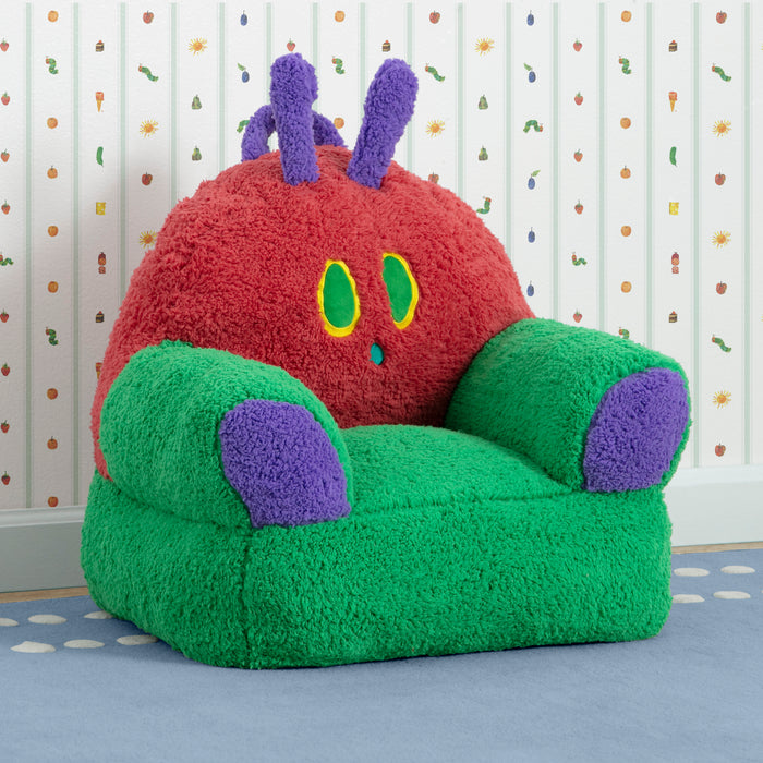 Children's chair designed like a cartoon caterpillar with red body, green wings, and purple antennas on a patterned floor.