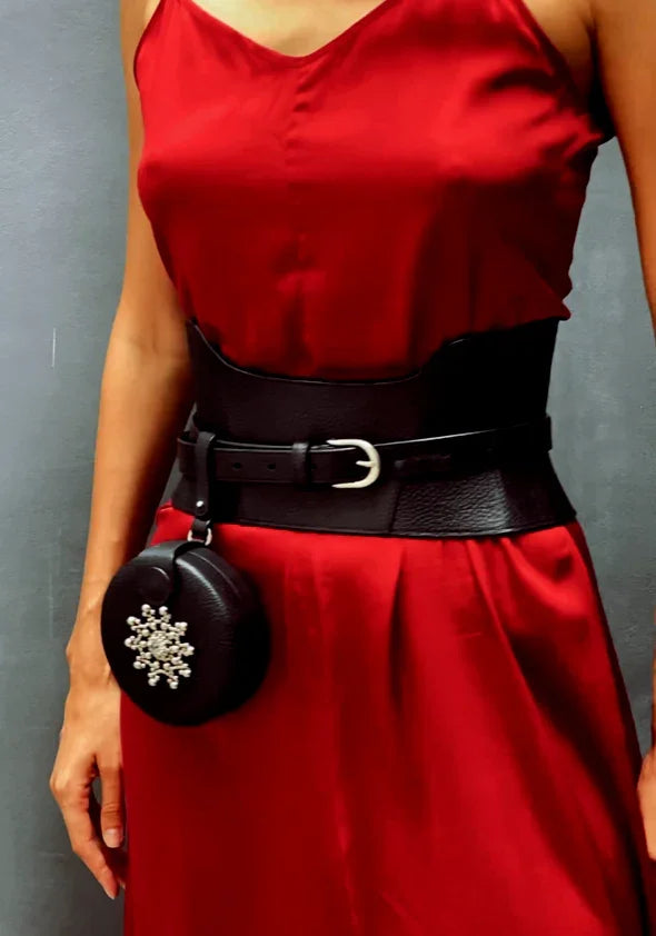 close up woman in red dress wearing zheng corset belt with leather coin bag by object & dawn in neutral background